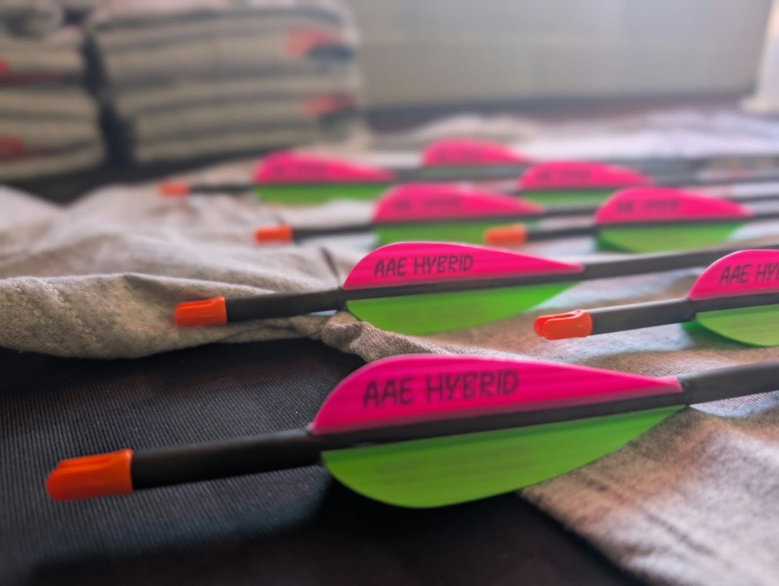 Custom-built arrows with pink and green fletching on the SinnerShot bench