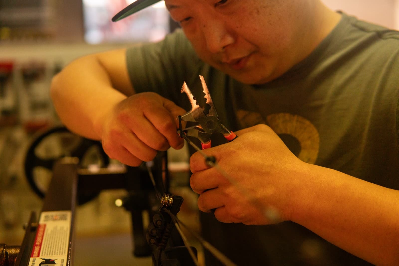 Cable work on a compound bow at the SinnerShot bench